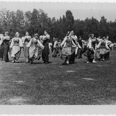 1959 m. gegužės 31 d. Šilutės rajoninė dainų šventė. Stadiono centrinėje aikštėje sukasi tautinių šokių šokėjų poros.