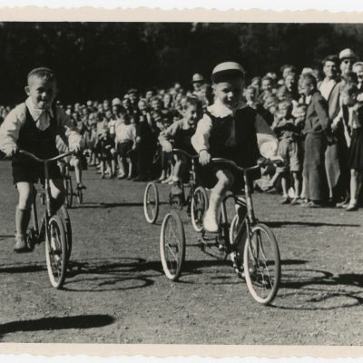 Bėgimo takuose lenktyniauja jaunieji dviratininkai.