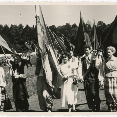 Kolonoje stadiono takais eina vėliavininkai, o paskui juos ir visi rajono jubiliejinės X dainų šventės dalyviai.